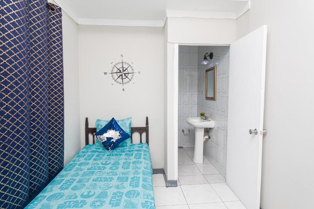 um quarto com uma cama azul na casa de banho em Caribic House em Montego Bay