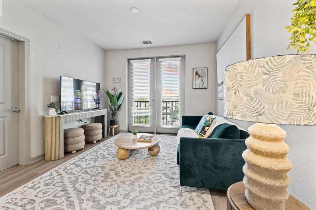 a living room with a green couch and a table at Tropical Field 1 Bed in Downtown With FREE Parking in St. Petersburg