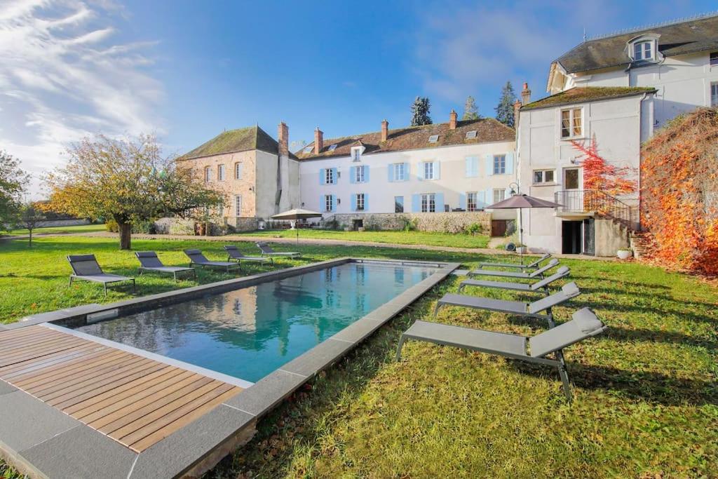 une piscine dans une cour à côté d'une maison dans l'établissement Maison Nelson, à Villecerf
