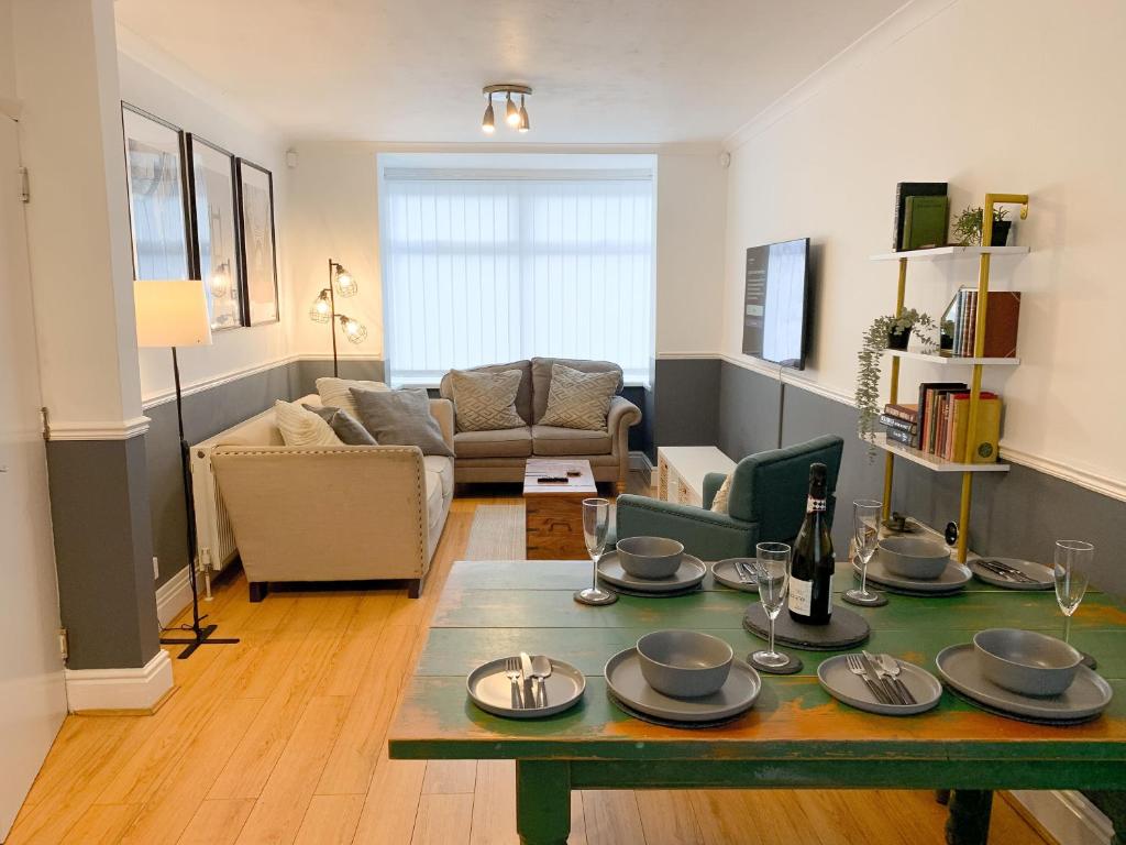 a living room with a table and a couch at Cosy 3 bed home with garden - near to uni, restaurants & bars in Hull