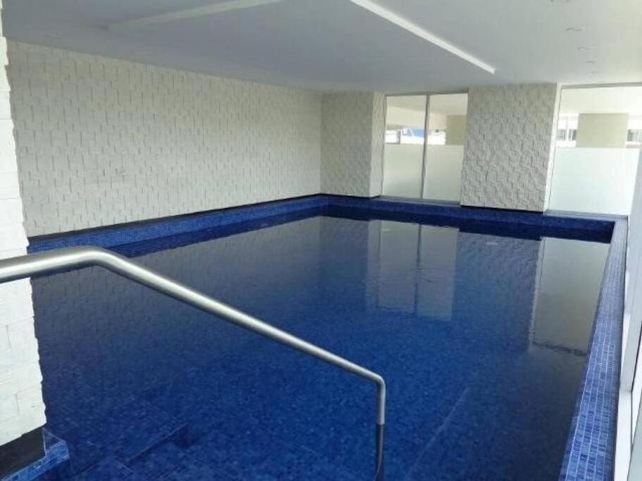 uma piscina com corrimão de metal num edifício em Ecusuites Apartamento Ejecutivo Hotel Sheraton Aeropuerto Quo em Guayaquil
