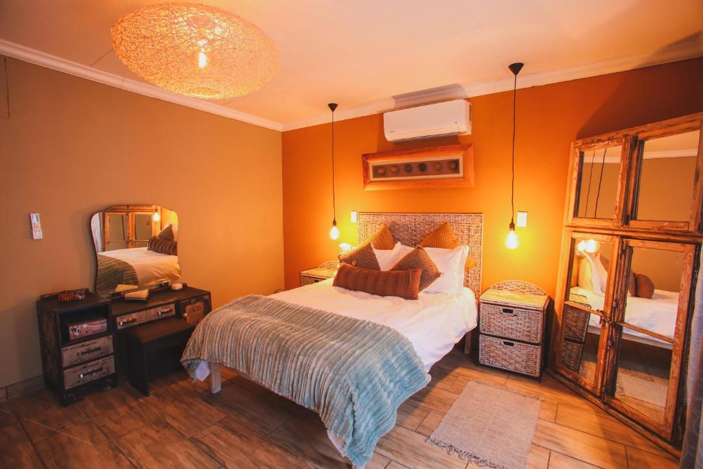 a bedroom with a large bed and a mirror at I Stay @ De 22 On Vintage in Windhoek