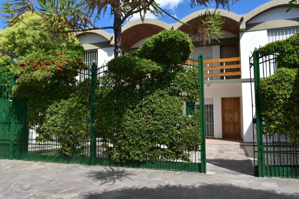 a green gate in front of a house at Complejo Turístico Hostal Madryn in Puerto Madryn