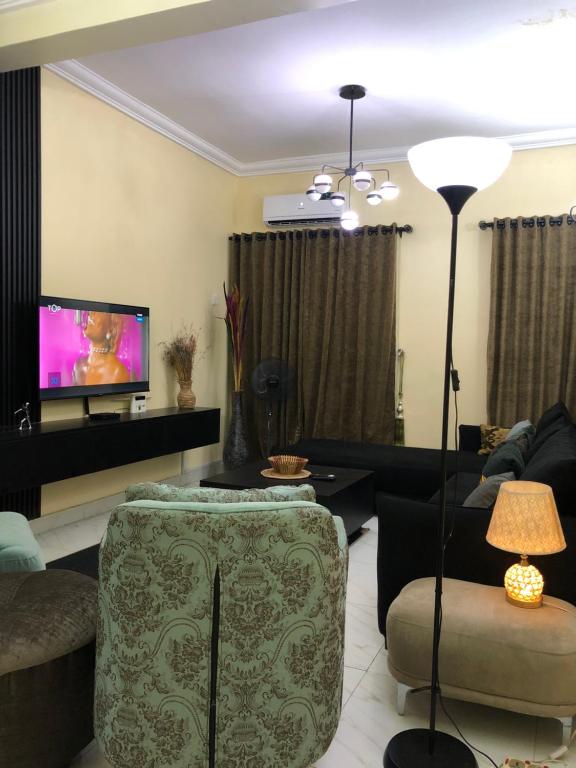 a living room with a couch and a tv at Furnished 2bedroom Apt in Wuye in Wupa