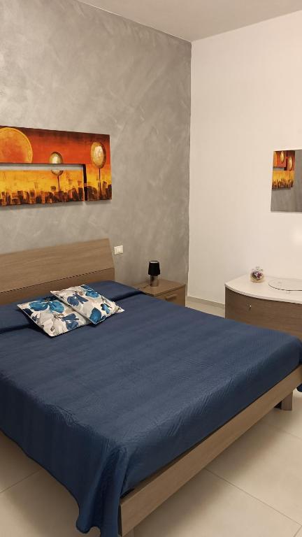 sypialnia z łóżkiem z niebieską narzutą w obiekcie Santa Genoveffa Apartment w Trapani