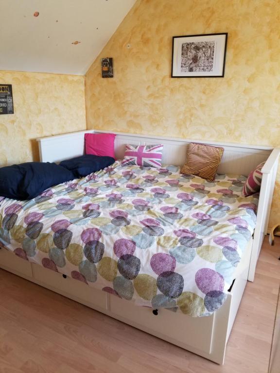a bedroom with a bed with a colorful comforter at Chez Loti in Louviers