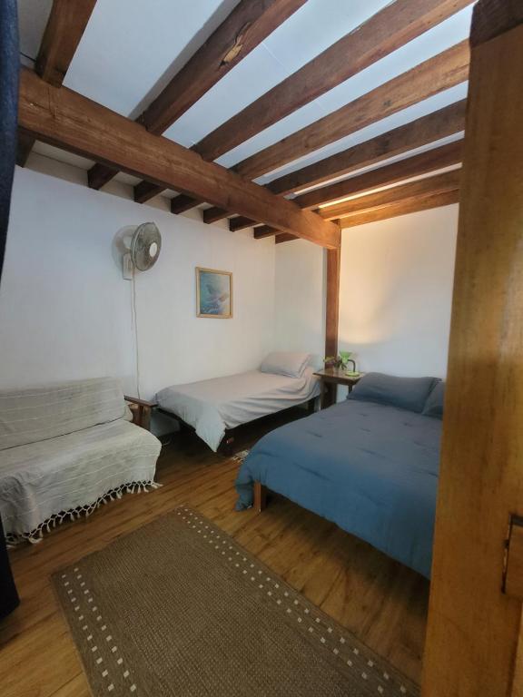 two beds in a room with wooden ceilings at Casa Encantada Guest House in La Aguada