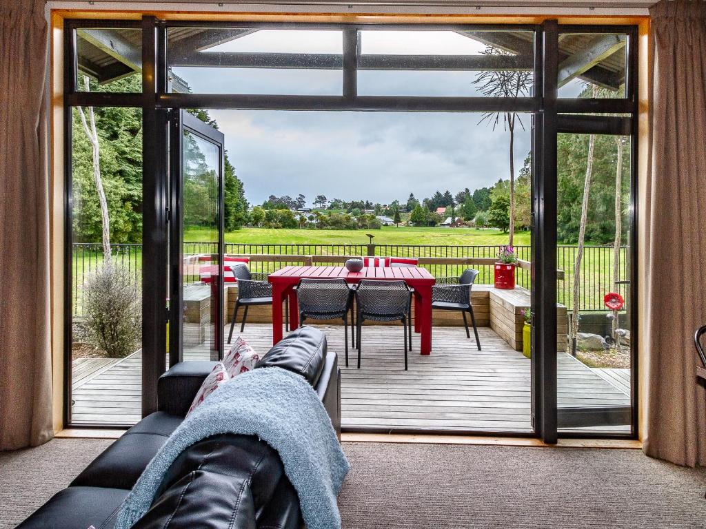 a screened in patio with a table and chairs at Ski Country Chalet - Ohakune Holiday Home in Ohakune