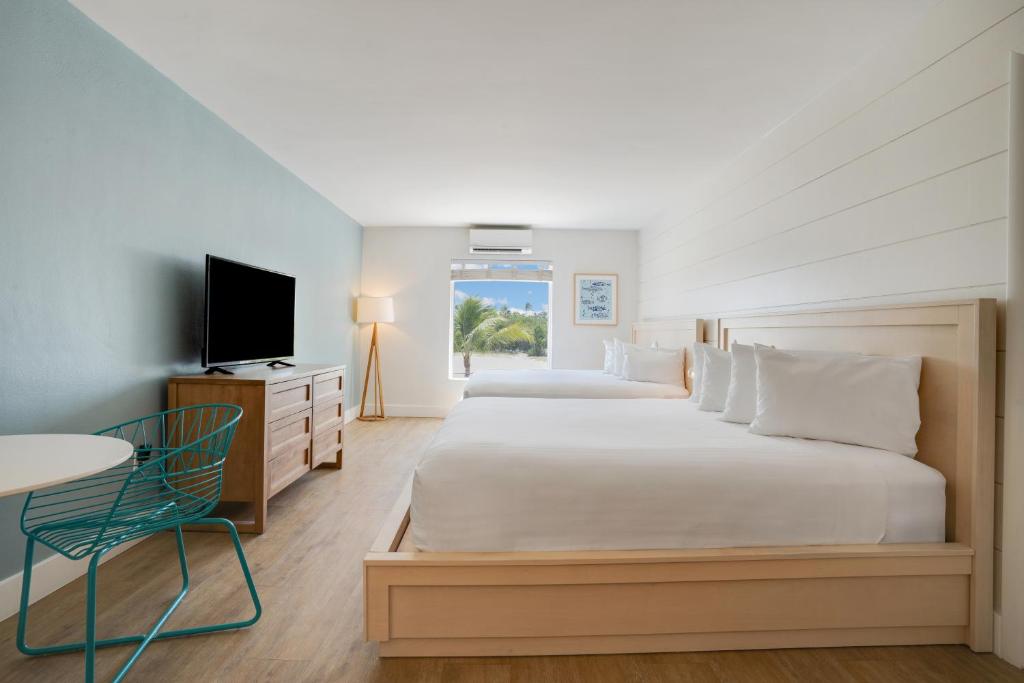 a bedroom with two beds and a flat screen tv at Fisher Inn Resort & Marina in Islamorada