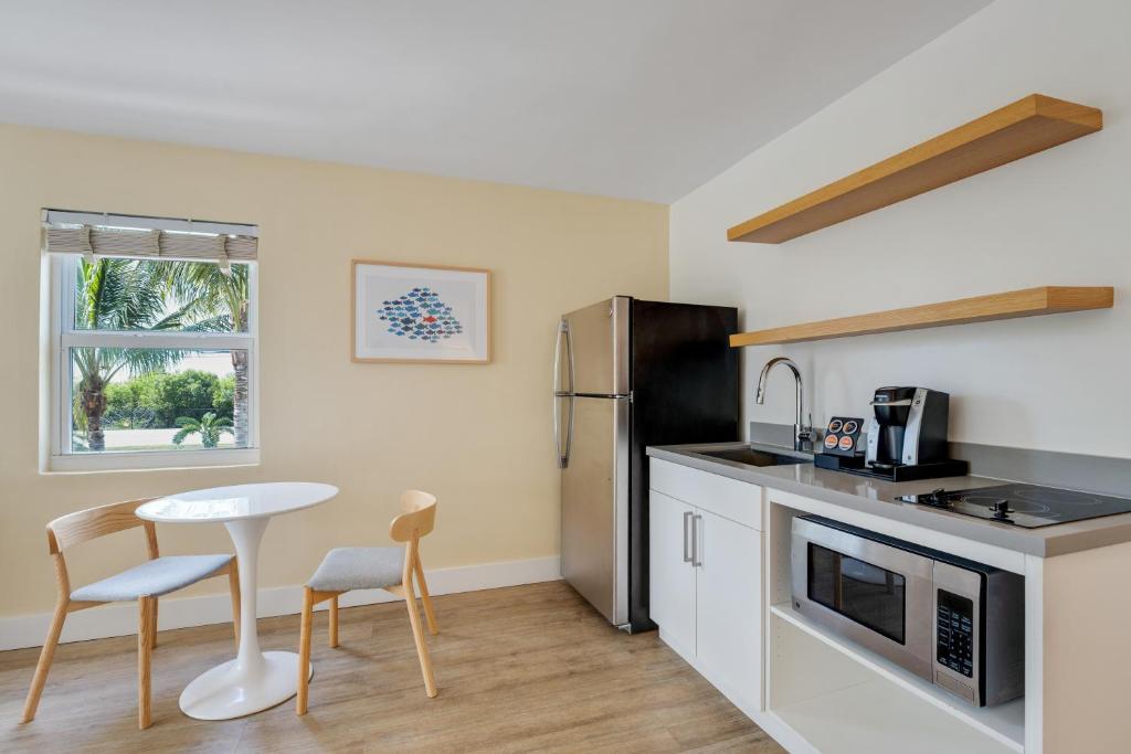 a kitchen with a table and chairs and a refrigerator at Fisher Inn Resort & Marina in Islamorada