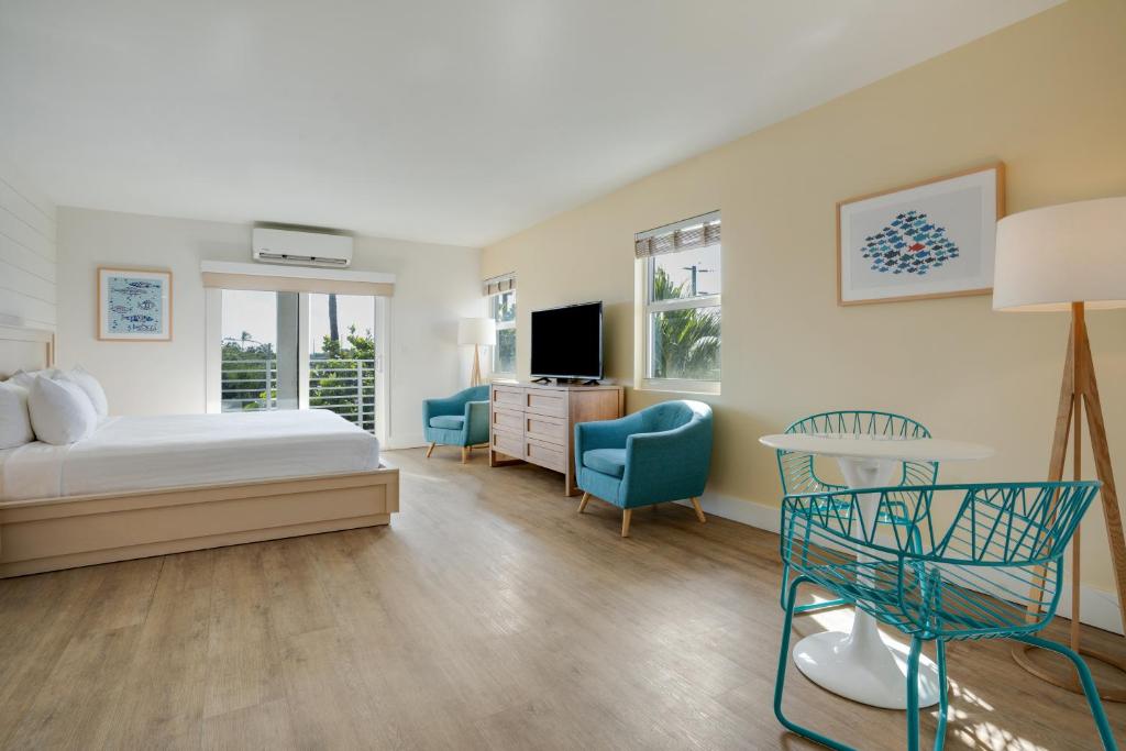 a bedroom with a bed and two chairs and a television at Fisher Inn Resort & Marina in Islamorada