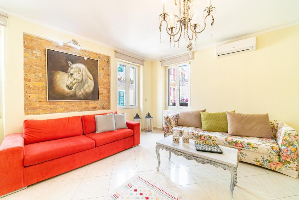 a living room with a red couch and a table at Maisonette in Corfu Town