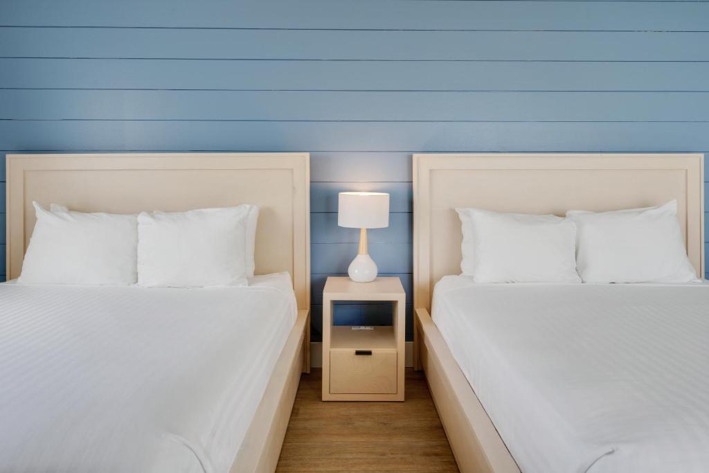 two beds sitting next to each other in a room at Fisher Inn Resort & Marina in Islamorada