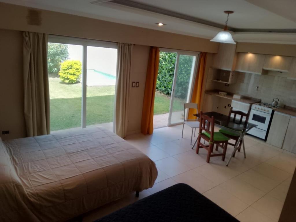 a bedroom with a bed and a table and a kitchen at LOS Teros dptos 3 5 3 4 0 9 2 8 1 5 in Villa María