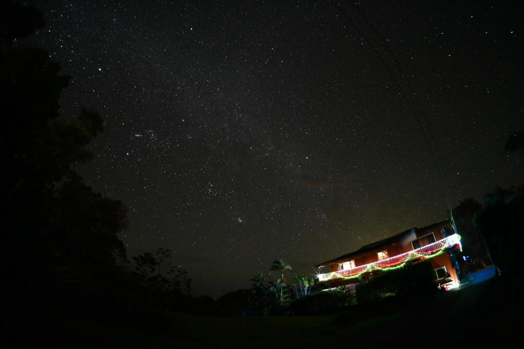 a starry night with a house with lights on it at Coffee Garden in Captain Cook