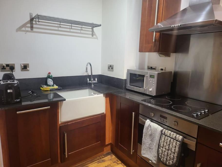 a kitchen with a sink and a stove top oven at Striking 1 bedroom apartment in Manchester