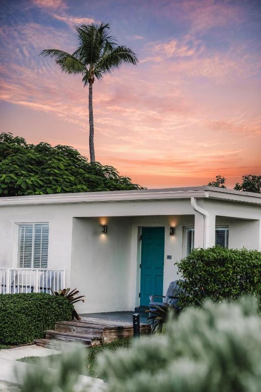 a white house with a palm tree in the background at Fisher Inn Resort & Marina in Islamorada