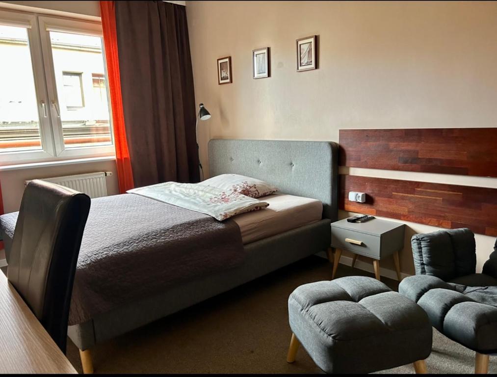 1 dormitorio con 1 cama, 1 silla y 1 ventana en Zajazd Alicja, en Kutno