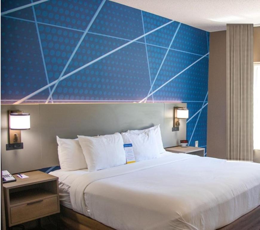 a large bed in a hotel room with a blue wall at Comfort Inn Sioux City South in Morningside