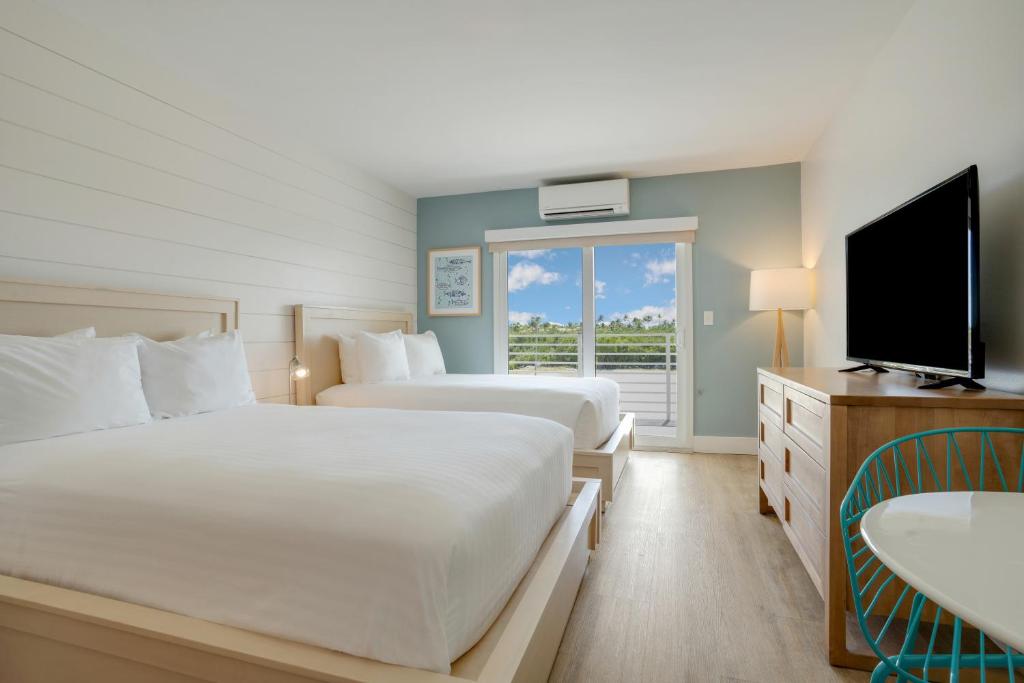 a hotel room with two beds and a television at Fisher Inn Resort & Marina in Islamorada