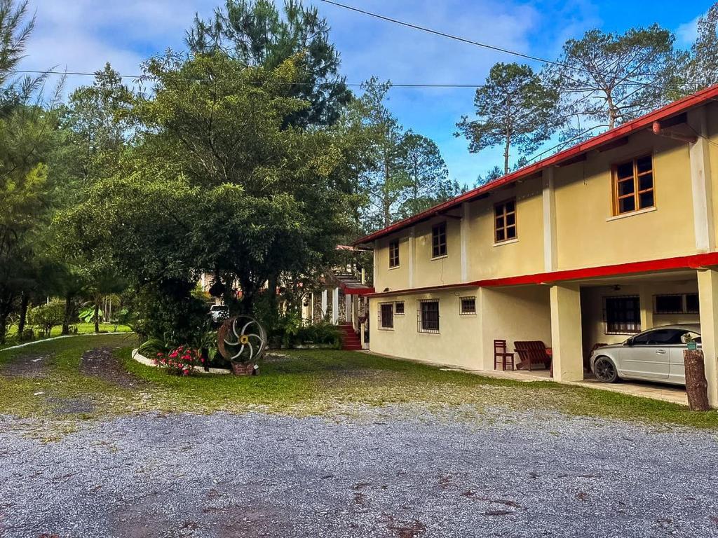 una casa con un coche aparcado delante de ella en Hotel Xucaneb, en Cobán