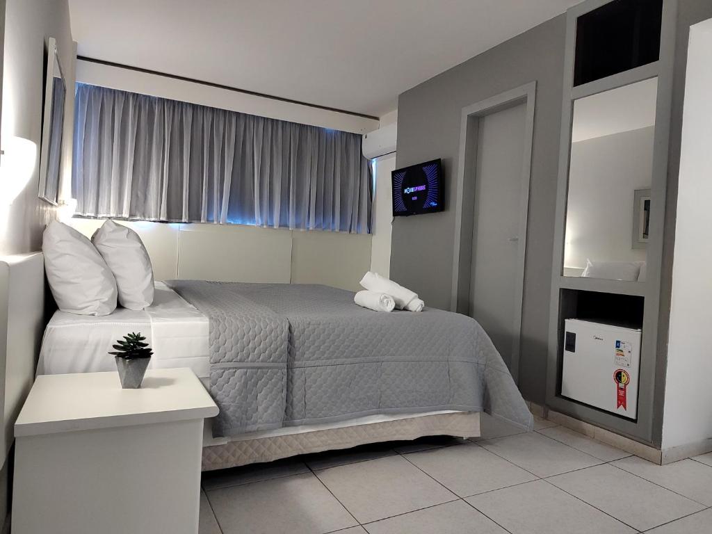 um quarto de hotel com uma cama e uma televisão em Hotel Oscar Gold Savassi em Belo Horizonte