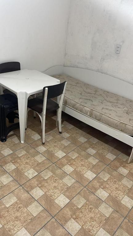 een tafel en een bed met een tafel en een stoel bij Kitnet na 262 in Itapema