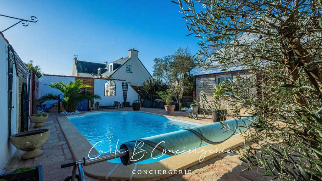 - une piscine avec toboggan en face d'une maison dans l'établissement ROBY - maison TREGUNC 6 personnes, à Trégunc