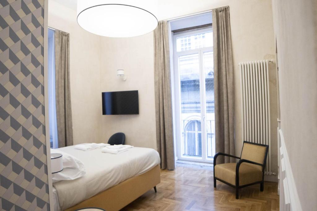 ein Hotelzimmer mit einem Bett, einem Stuhl und einem Fenster in der Unterkunft Librai suite in Neapel
