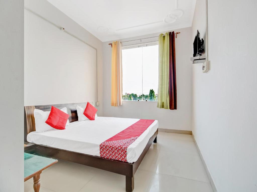 a bedroom with a bed and a window at Collection O Sangam Hotel in Chirāwa