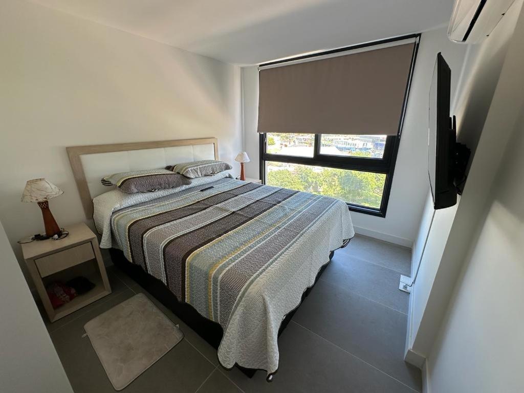 1 dormitorio con cama y ventana en View 3, en Punta del Este