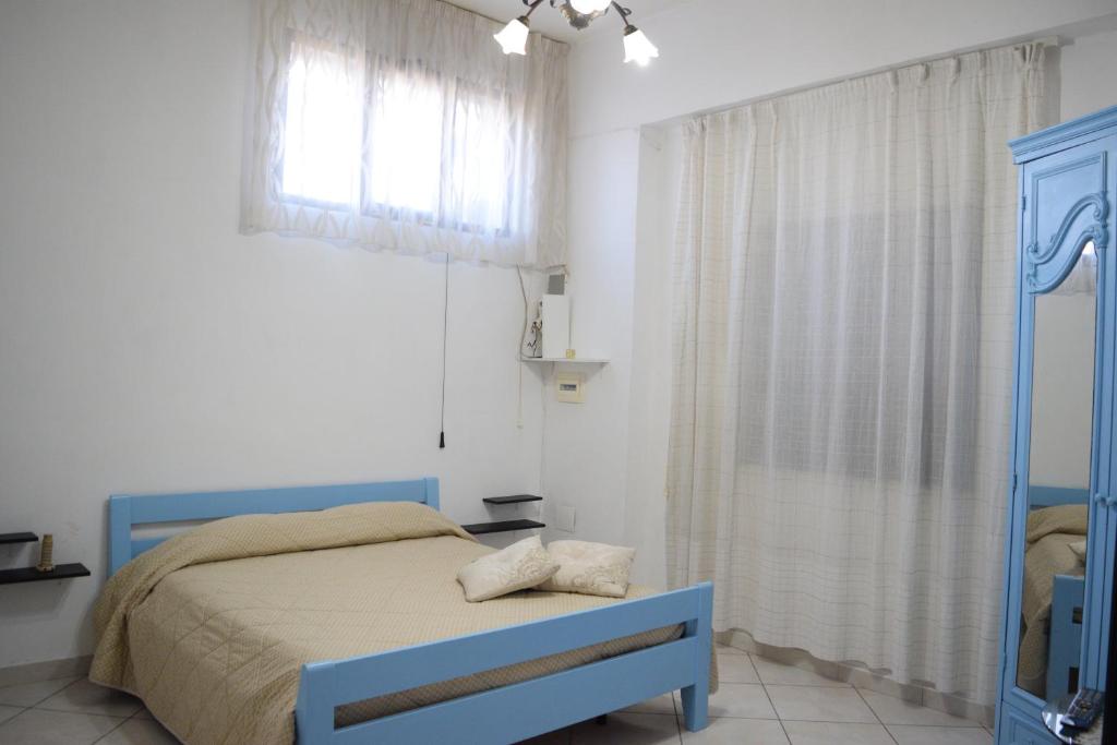 Un dormitorio con una cama azul y una ventana en B&B Il Sole, en Torre Annunziata