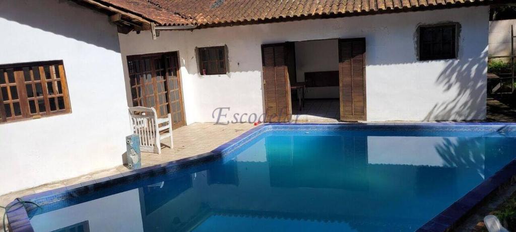 a swimming pool in front of a house at Cantinho da Eli - Pousada com Piscina in Mairiporã
