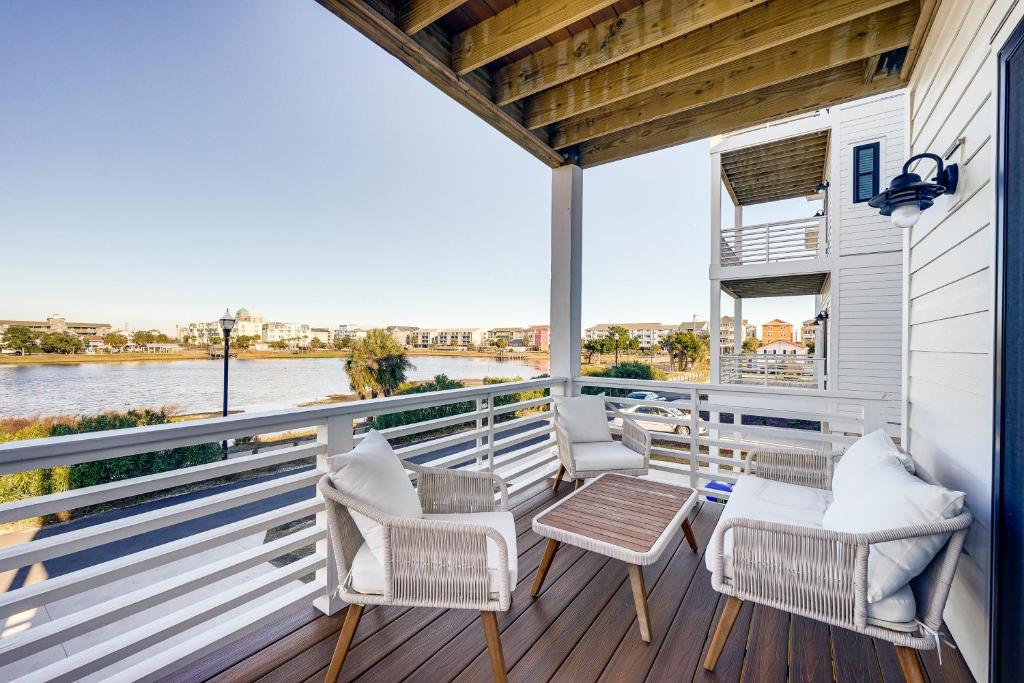 een balkon met stoelen en een tafel en uitzicht op het water bij Lakefront Carolina Beach Townhome with 3 Balconies! in Carolina Beach