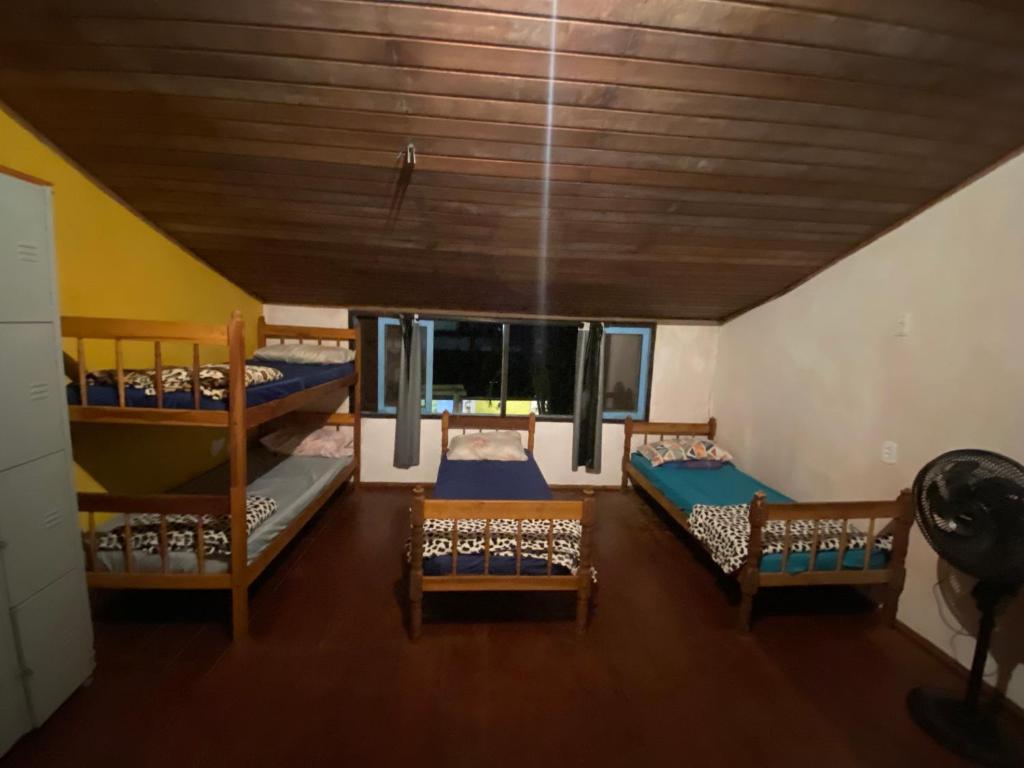 a room with three bunk beds and a ceiling at Casa Lee Hostel in Paraty