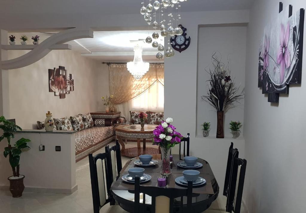 ein Wohnzimmer mit einem Tisch und einem Sofa in der Unterkunft Appart-ines l'Oasis du confort et luxe in Oujda