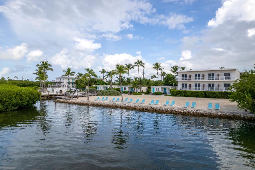 a body of water with blue chairs and buildings at Fisher Inn Resort & Marina in Islamorada