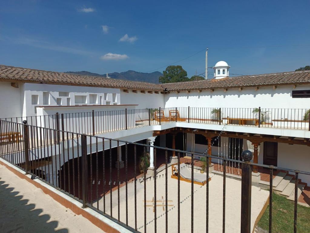 a white building with a fence and a patio at Taura in Antigua Guatemala