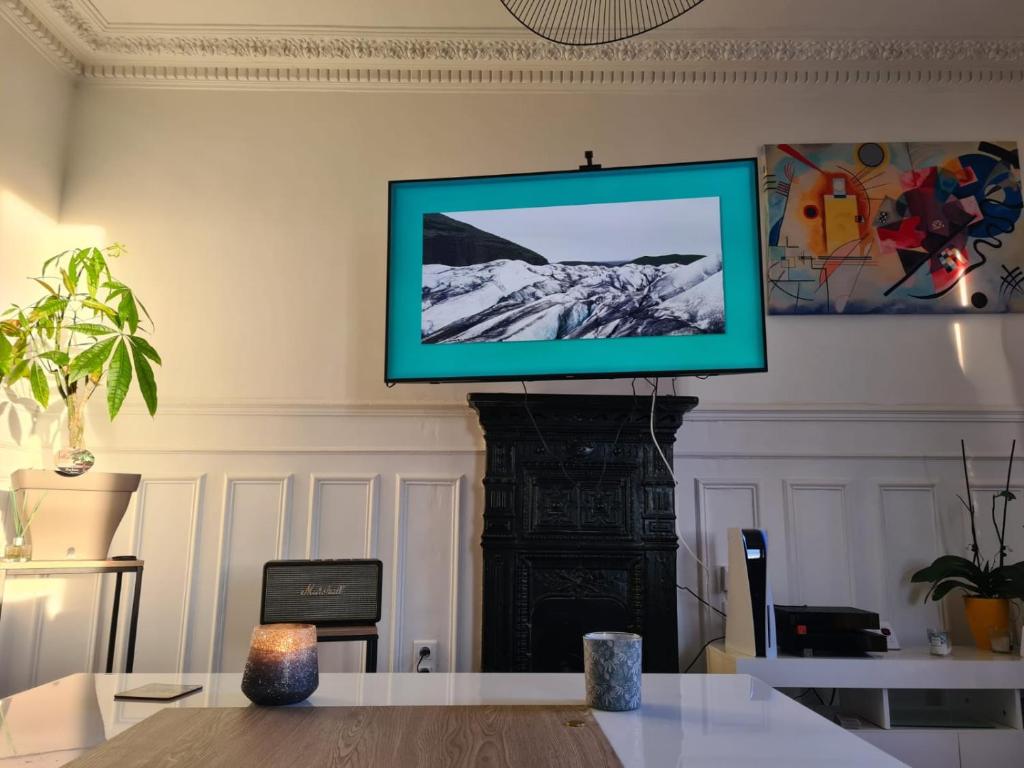 - une télévision murale dans le salon dans l'établissement Magnifique appartement La Défense 10min Pte Maillot, à Courbevoie