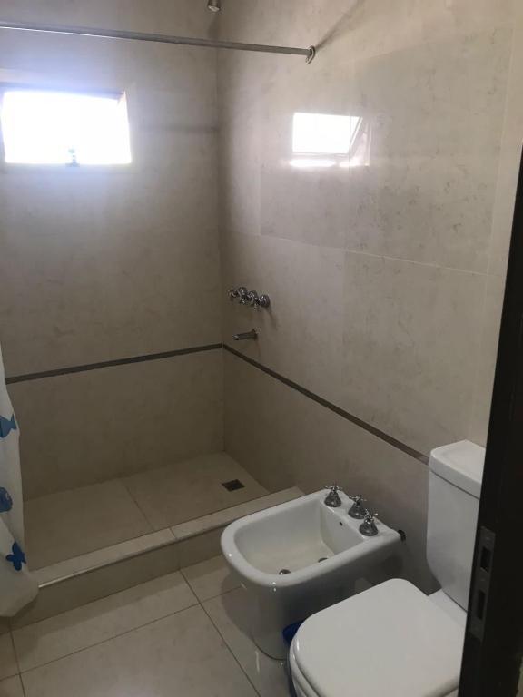 a bathroom with a toilet and a shower and a sink at Depto Zeus in Resistencia