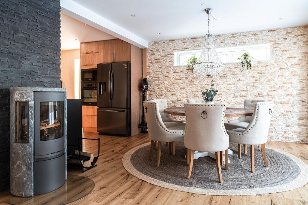 cocina con mesa, sillas y chimenea en Guestly Homes - 4BR Cozy Corporate Villa, en Piteå