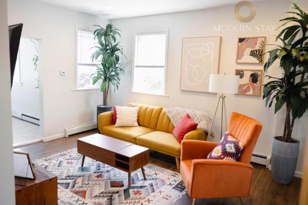 a living room with a yellow couch and two chairs at Rainforest Retreat 20m to NYC FREE Parking in Bayonne