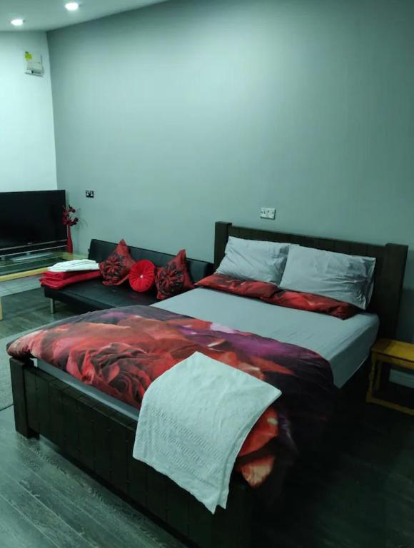 a bedroom with a large bed with red sheets at Rooms for rent in Solihull in Solihull