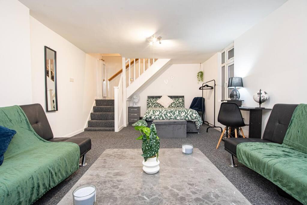 - un salon avec deux canapés verts et une table dans l'établissement Watford Central Serviced Apartments, à Watford