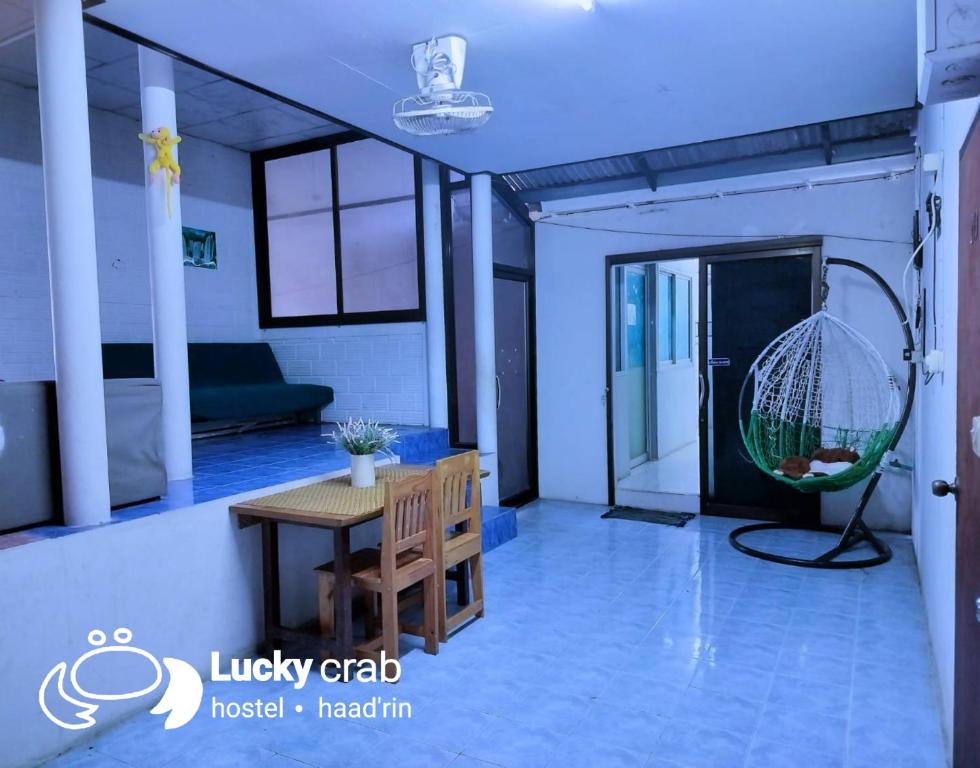 ein Wohnzimmer mit einem Tisch und einer Schaukel in der Unterkunft Lucky Crab Hostel in Haad Rin