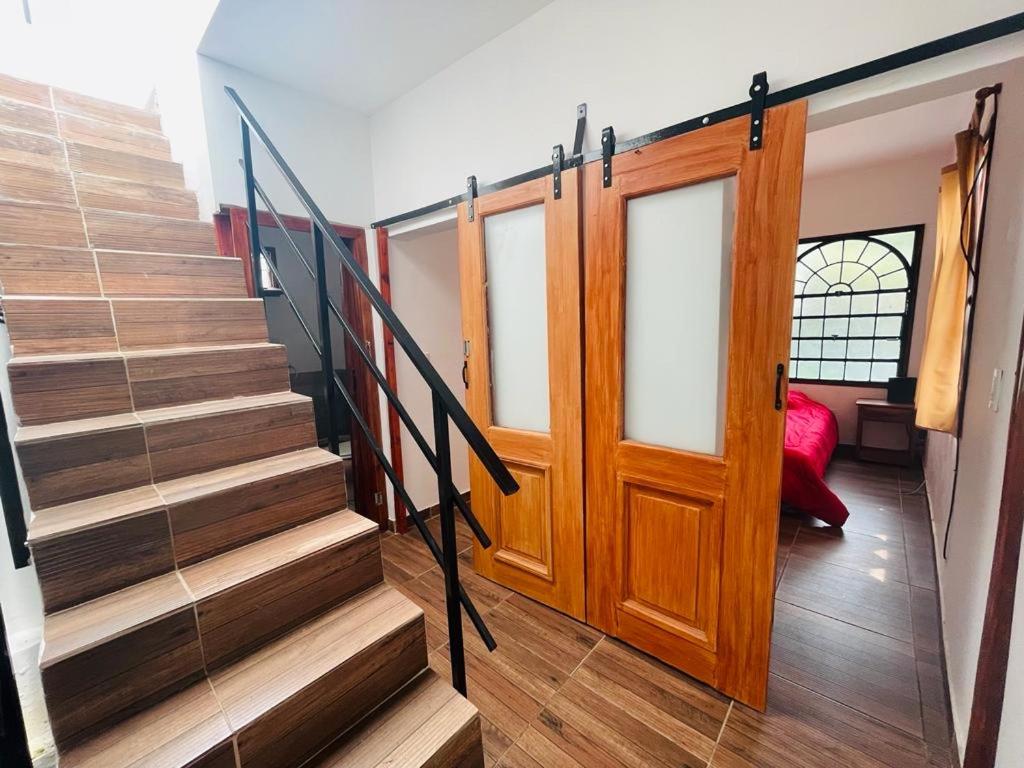 a staircase in a house with a wooden door at Mini house con sol y luz in Buenos Aires
