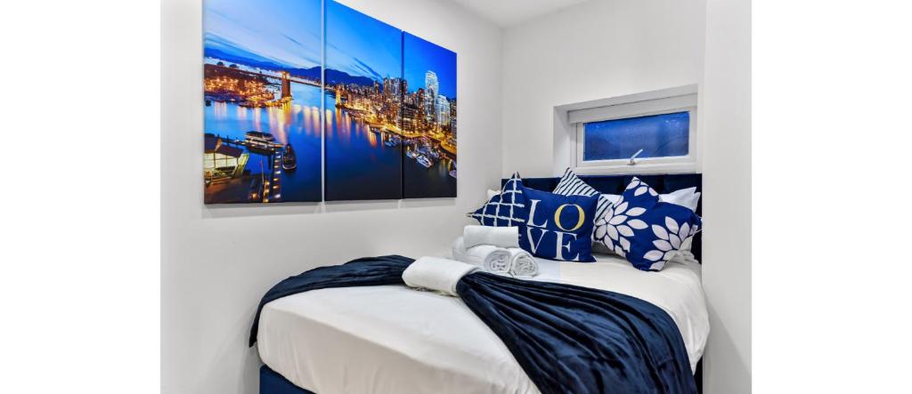 Comfortable and Stylish 1 BR flat - Sleeps 2 في لندن: غرفة نوم مع سرير ووسائد زرقاء وبيضاء