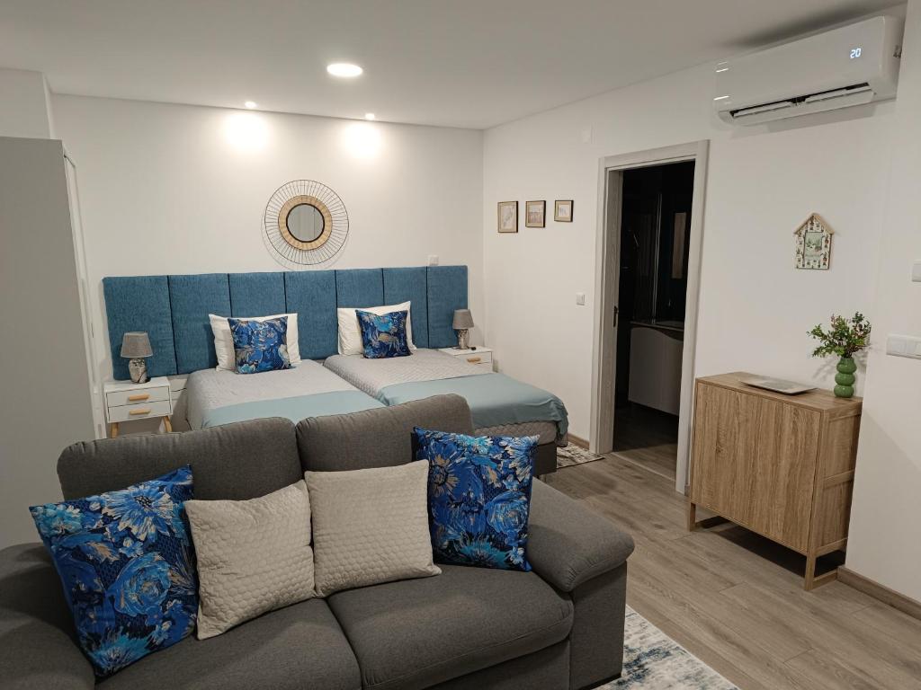 sypialnia z łóżkiem i kanapą w pokoju w obiekcie Garden House Fundão - Suíte 202 com varanda w mieście Fundão