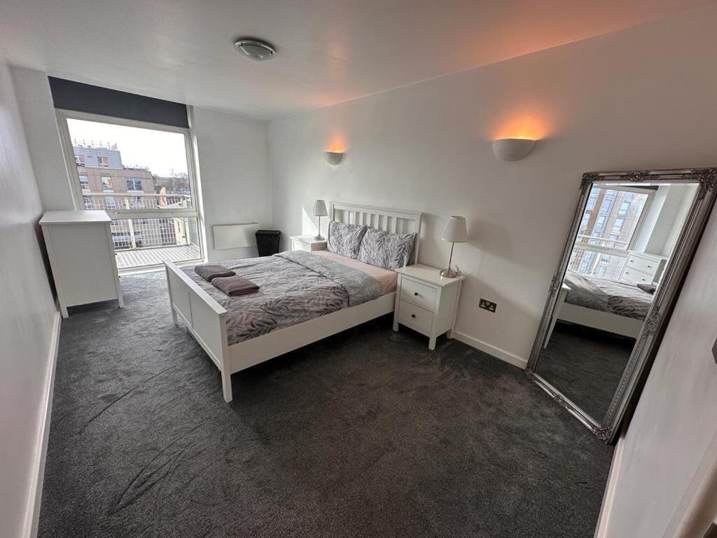 1 dormitorio con cama y espejo grande en Recently Refurbished Apt central MK FREE PARKING en Milton Keynes