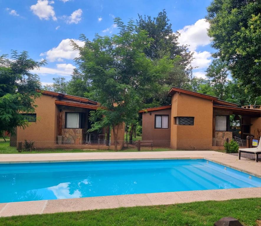 ein Haus mit einem Swimmingpool im Hof in der Unterkunft CABAÑAS SUKHA in Santa Rosa de Calamuchita